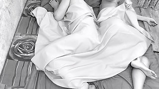 Couple caught on camera having sex in bed .
