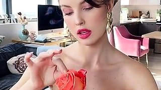 Beautiful busty MILF in red panties plucking rose petals